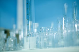 Clear Scientific Beakers and Test Tubes on Blue Background