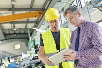 Factory Worker and Manager Looking at Wireless Tablet on Plant Floor