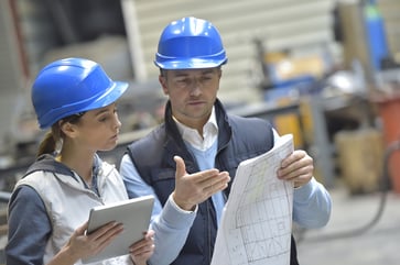 Male and Female Engineers Discussing Data on Plant Floor