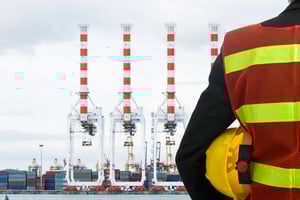 factory worker in reflective vest with plant behind