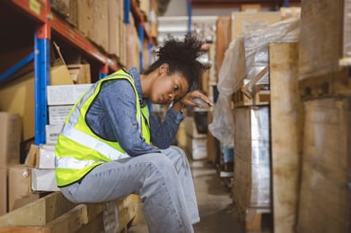 female-worker-sitting-upset-warehouse