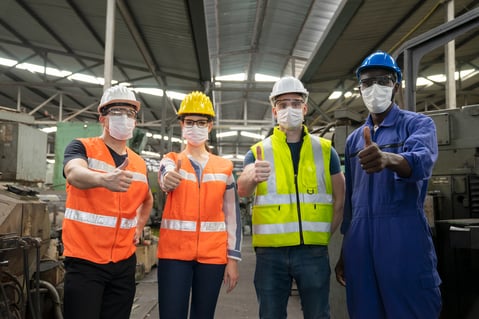 four-manufacturing-workers-thumbs-up-safety-vests