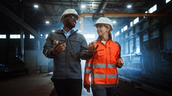 male-female-factory-workers-walking-talking