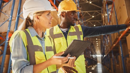 male-female-hardhats-warehouse-tablet