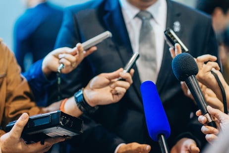 man-in-suit-during-press-conference