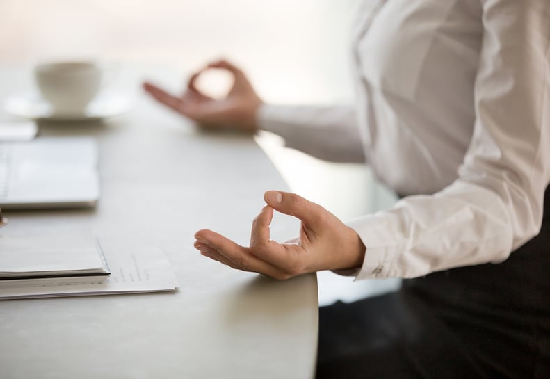 woman-torso-hands-yoga-pose-at-desk